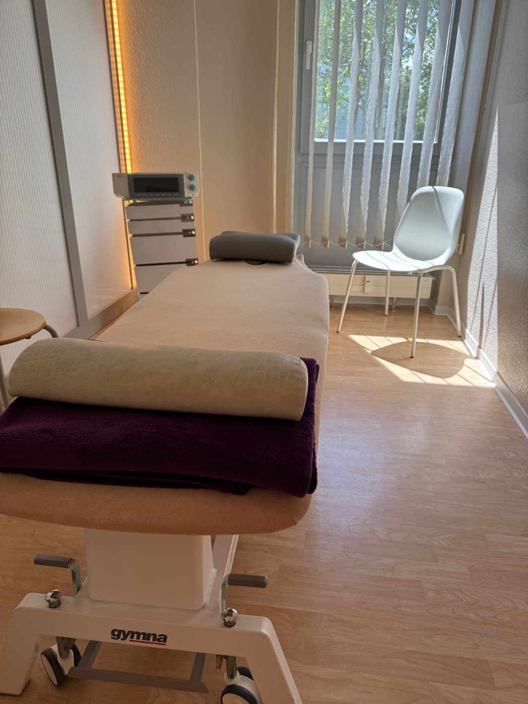 Behandlungsraum mit Therapieliege und Trainingsgeräten