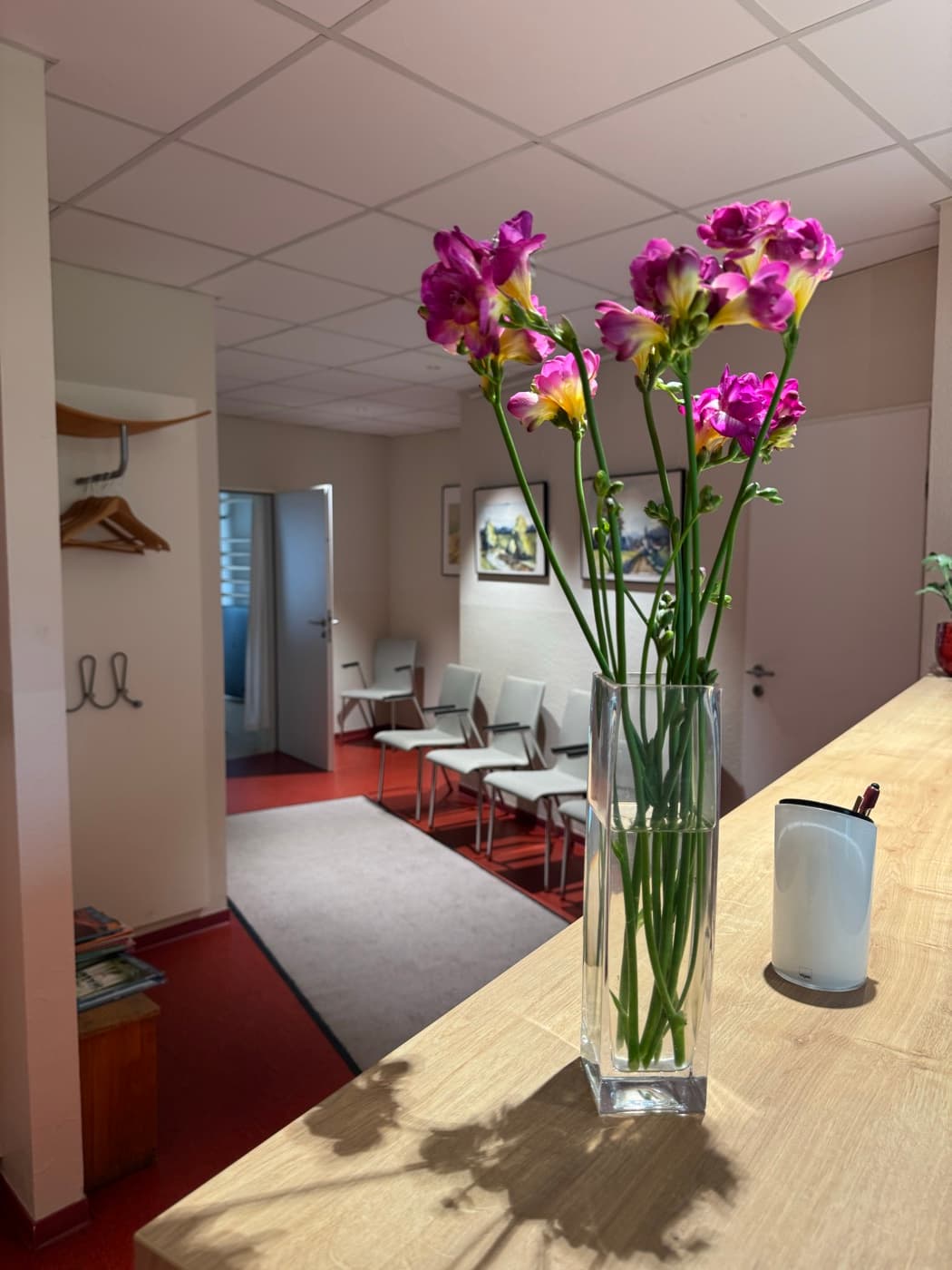 Wartebereich mit frischen Blumen der Praxis Schlesinger